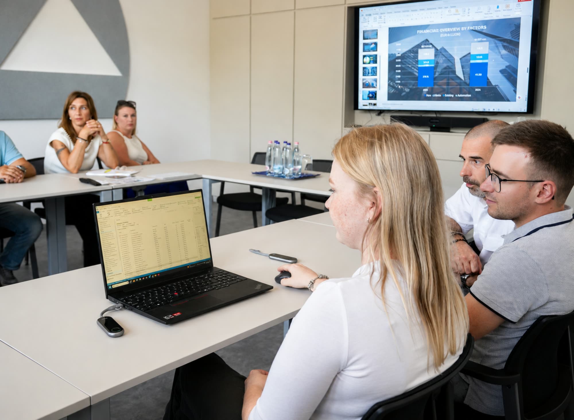 KÖNIG colleagues reviewing project figures together around a laptop